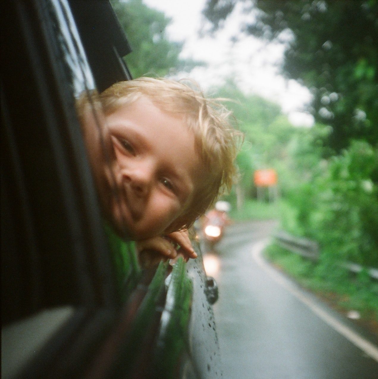 child peeking from vehicle window